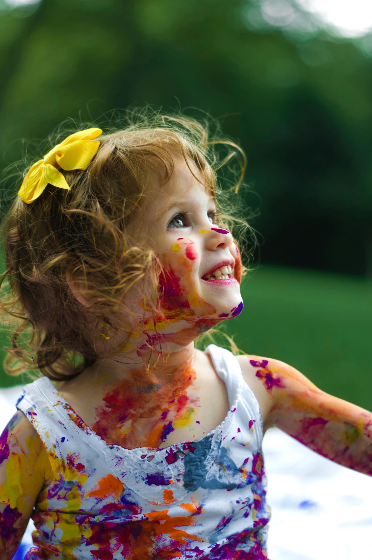 En lille pige, med maling i ansigtet, smiler
